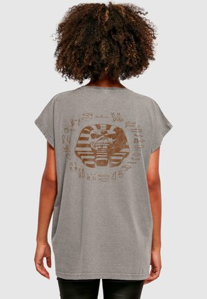 T-shirt gris surdimensionné en tissu doux, présentant un grand motif inspiré de l'Égypte ancienne avec des hiéroglyphes au dos.