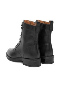 Czarne skórzane botki za kostkę o gładkiej fakturze, z wiązanym przodem i niskim obcasem. Posiadają pętelkę z tyłu oraz jasnobrązowe wnętrze.