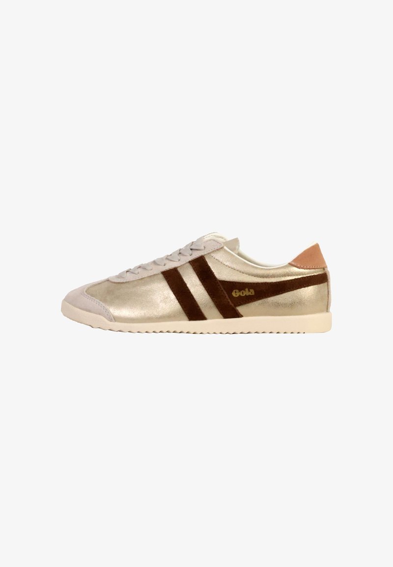 Zapatilla metálica dorada con franjas de ante marrón, suela blanca y detalle de cuero beige en el talón; presenta un diseño clásico de cordones y un acabado texturizado.