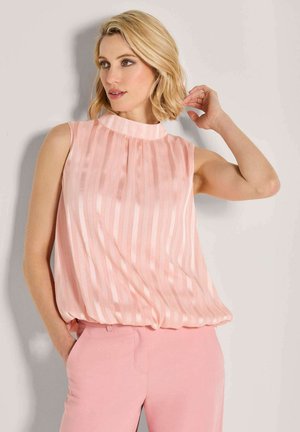 Ärmellose Bluse in Hellrosa mit vertikalen Streifen, aus weichem Stoff, mit hohem Kragen und lockerer Passform, kombiniert mit passenden rosa Hosen.