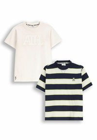 Dwa t-shirty: jeden w jednolitym kremowym kolorze z uniesionym białym logo, drugi w granatowo-białe paski z zielonymi akcentami i logo na klatce piersiowej.