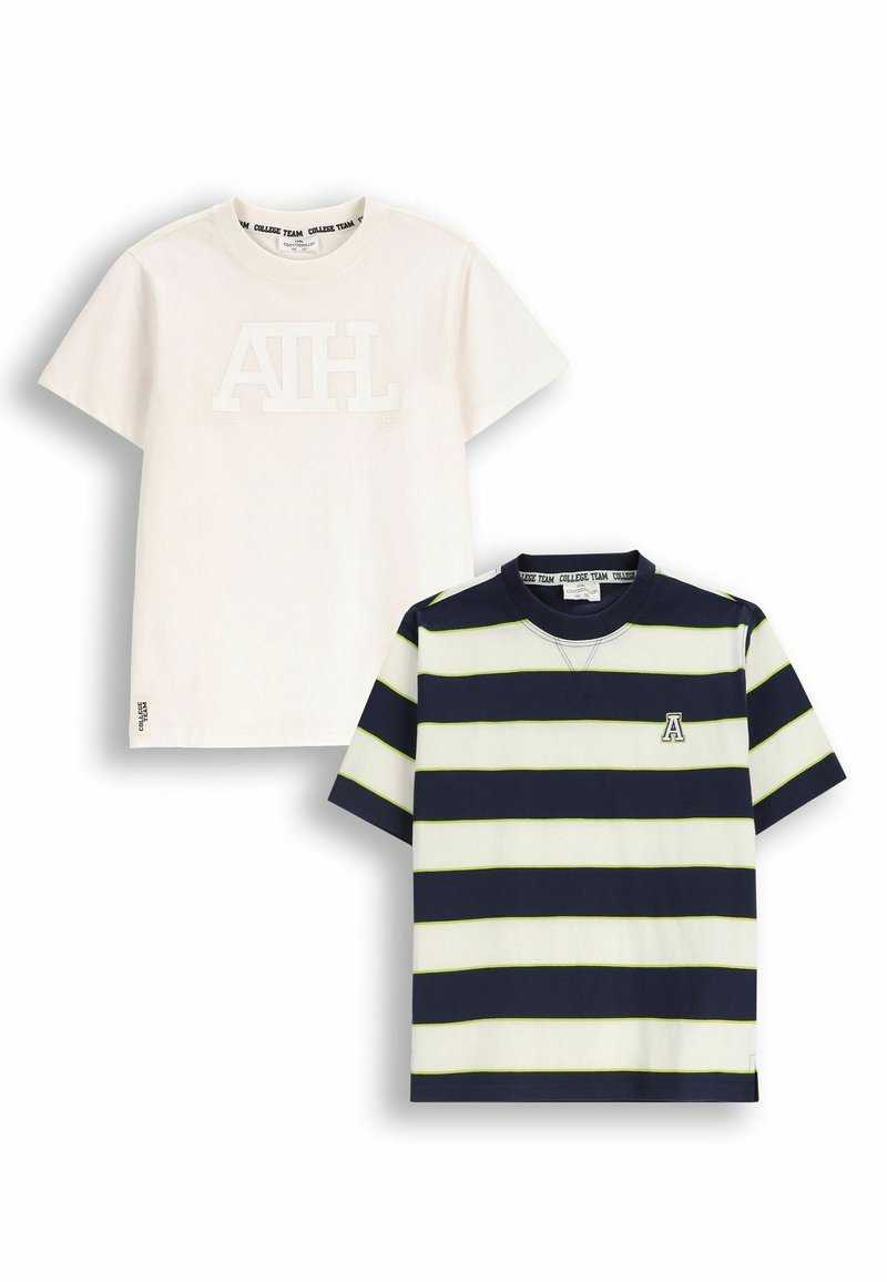 Dwa t-shirty: jeden w jednolitym kremowym kolorze z uniesionym białym logo, drugi w granatowo-białe paski z zielonymi akcentami i logo na klatce piersiowej.