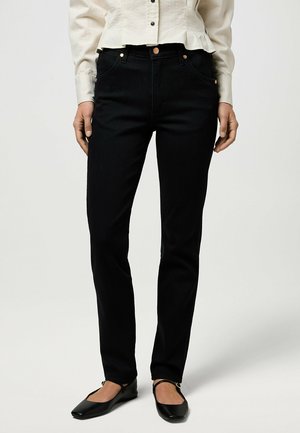 Svarta denimjeans med slim fit, med kopparnitar, framfickor och en slät textur. Matchas med svarta platta skor.