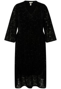 Abito in velluto nero con scollatura a V, maniche lunghe e motivo floreale. L'orlo è leggermente svasato, con una finitura testurizzata.