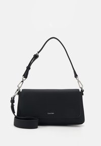 Sac à main en synthétique noir avec une texture lisse, fermeture à rabat et une bandoulière amovible. Équipé de quincaillerie en argent et du logo de la marque.