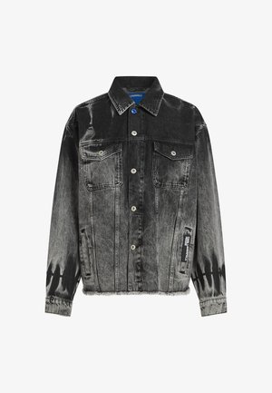 Jaqueta de denim preto e cinza com um padrão desbotado, dois bolsos no peito, botões de pressão e uma barra desfiada. Apresenta uma etiqueta na lateral.