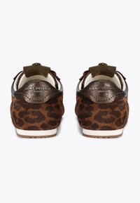 Bruine sneakers met een luipaardprint in suede, metalen accenten en een contrasterende donkere achterkant met een decoratieve vetersluiting.