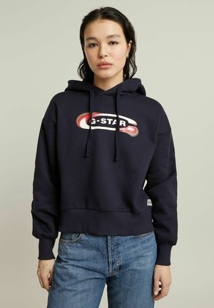 Granatowy hoodie z kapturem ze sznurkiem, z czerwono-białym logo G-Star z przodu. Ściągacze przy mankietach i u dołu, wykonany z miękkiego materiału.