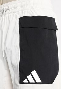 Lichte, elastische shorts met een grote zwarte zak en witte accenten. Gemaakt van een soepele stof met een mix van zwart en wit.