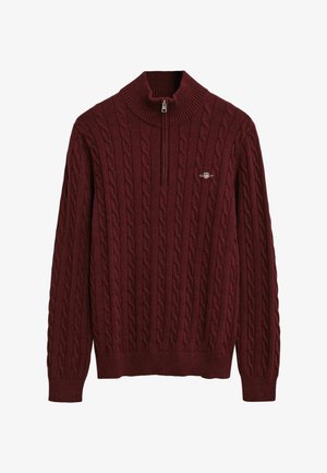 Bordeaux kabelgebreide trui met een hoge kraag en een kwart-rits. Heeft ribgebreide manchetten en onderrand, met een klein logo op de borst.
