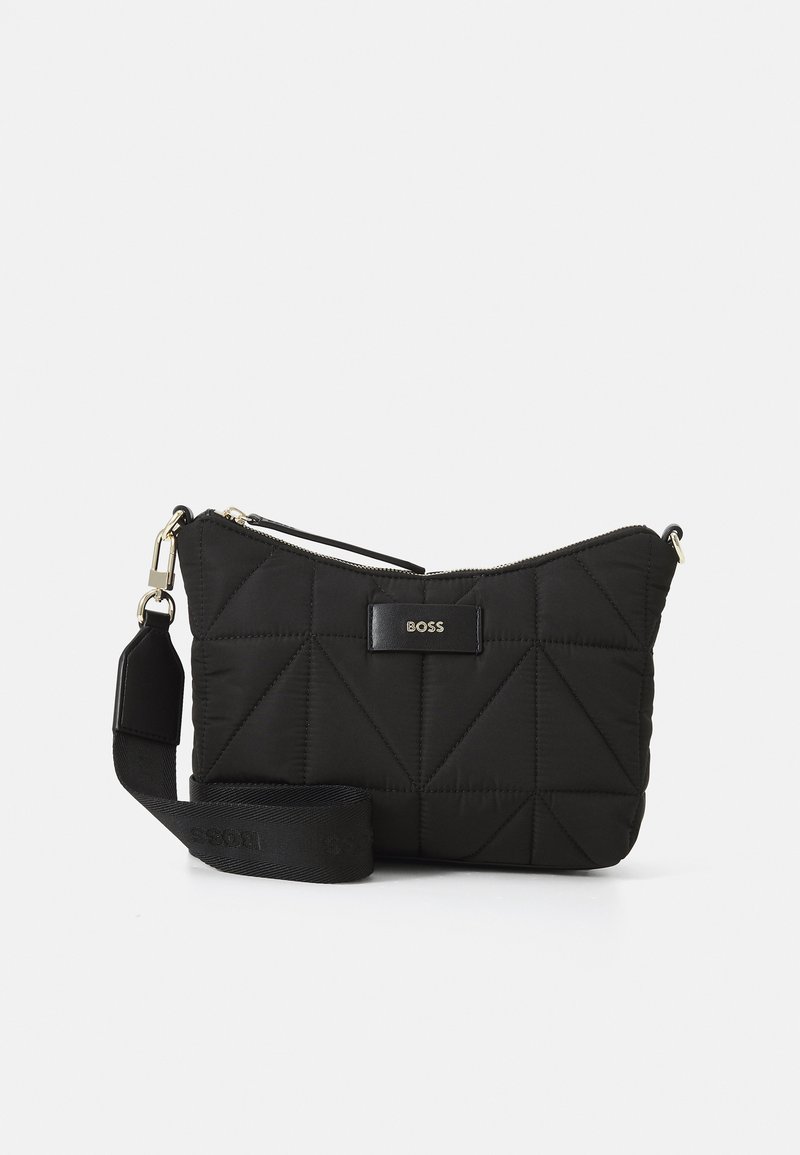 Čierna prešívaná nylonová crossbody taška s geometrickými vzormi, dvojitými hornými zipsami a logom, s nastaviteľným popruhom a zlatým kovovým hardvérom.