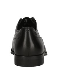 Chaussure habillée en cuir noir, avec un bout arrondi, une texture lisse, des coutures discrètes et une semelle discrète pour un confort optimal.