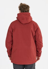 Rote wasserdichte Jacke mit Kapuze, die eine glatte Textur und eine lockere Passform bietet. Enthält eine horizontale Naht über den Rücken.