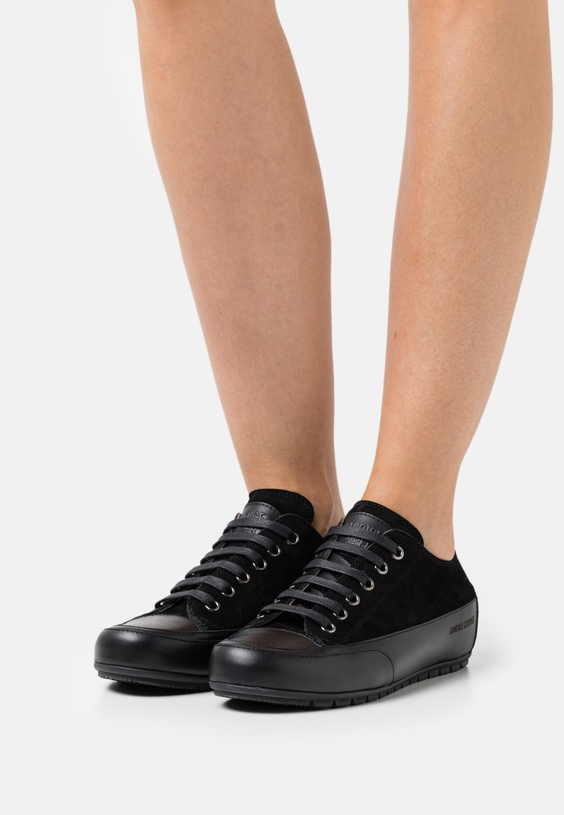 Czarne sneakersy z połączeniem gładkiej skóry i zamszu, okrągłym noskiem, sześcioma oczkami i teksturowaną gumową podeszwą.