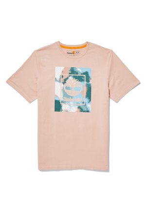 Lyserød kortærmet T-shirt med et firkantet grafik af et trælogo i blå, hvid og ferskenfarve på forsiden.