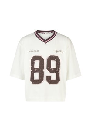 White short-sleeve cropped shirt with V-neck, striped collar, large distressed number 89, and text "COME AS YOU ARE" and "New York Club."
