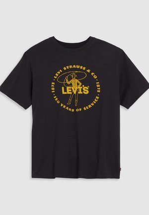 T-shirt en coton noir avec un graphique jaune d'un cow-boy, accompagné du texte "LEVI'S" et "LEVI STRAUSS & CO." dans un design circulaire. Manches courtes, col rond.