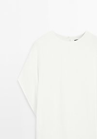 Witte blouse met lange mouwen en een ronde hals, van voren getoond op een witte achtergrond.