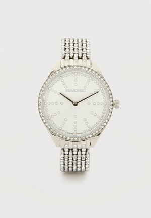 Hõbedase tooniga Swarovski käekell, millel on kristallidega kaunistatud raami serv, sihverplaadi märgid ja võrkrihm, kell näitab aega 10:10.