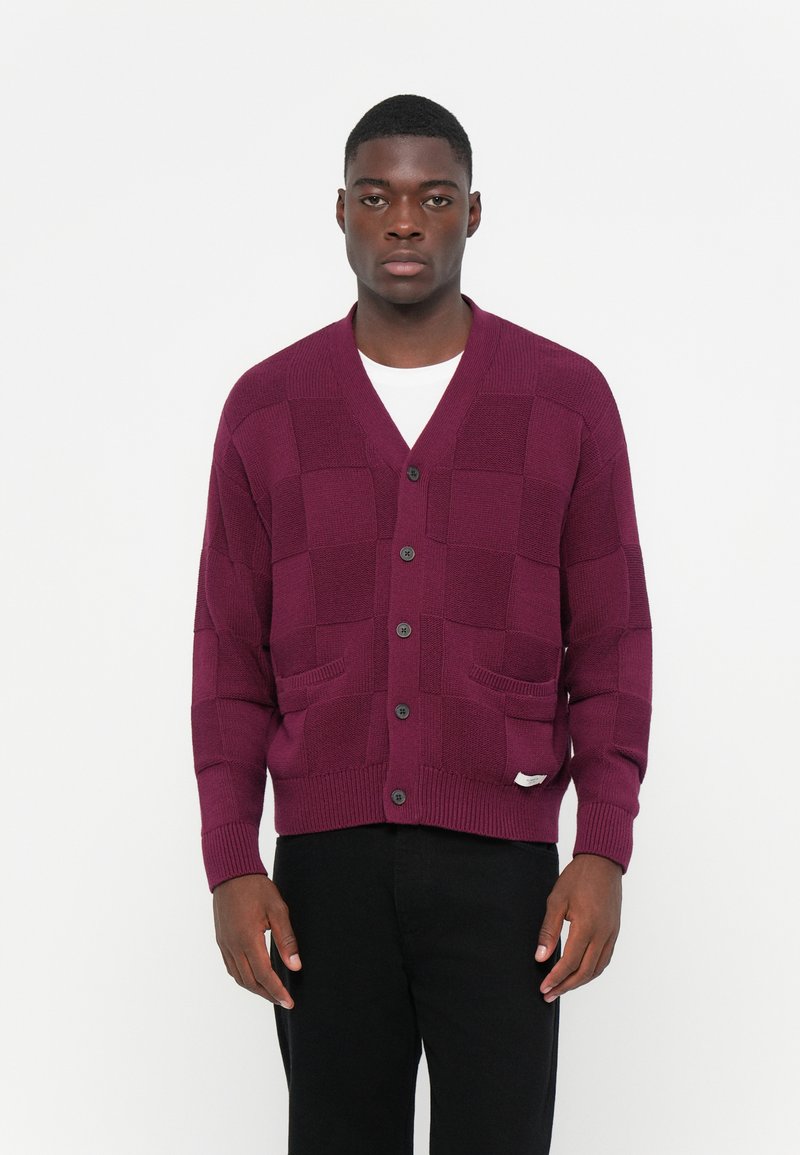 Cardigan a maglia bordeaux con motivo a scacchi, scollo a V, sei bottoni neri e due tasche frontali, realizzato in materiale testurizzato.