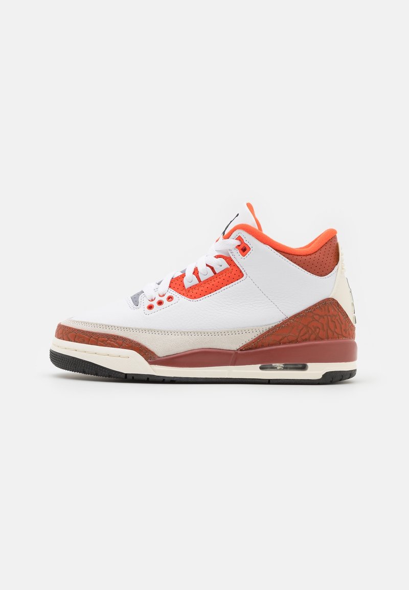 White leather sneaker with orange accents, gray midsole, and textured red heel. Features a classic design and visible Air unit in the sole.