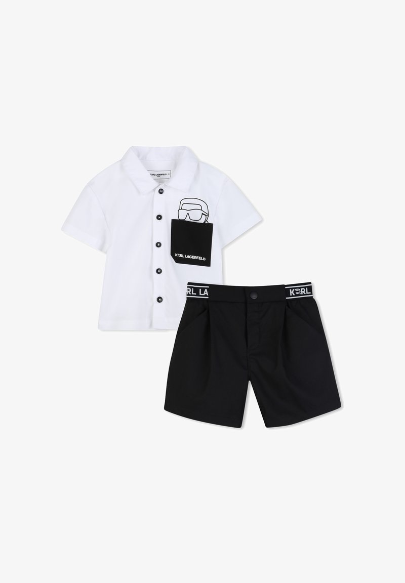 Άσπρο πουκάμισο με κοντά μανίκια και κουμπιά, με μαύρη τσέπη και σορτς που φέρουν το λογότυπο "Karl Lagerfeld" στην τσέπη και τη μέση.