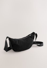 Zwarte corduroy heuptas met een slank ontwerp, voorzien van een ritssluiting, verstelbare band en een zachte, gestructureerde oppervlakte.