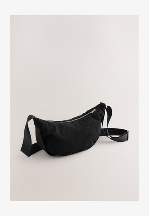 Musta corduroy-mallinen vyölaukku, jossa tyylikäs muotoilu, vetoketjusuljenta, säädettävä olkahihna ja pehmeä, teksturoitu pinta.