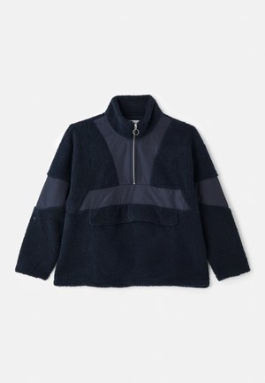 Pull-over en polaire bleu marine avec un col montant, une demi-fermeture éclair et des panneaux en tissu lisse contrastants. Sa texture douce et sa coupe décontractée ajoutent au confort.