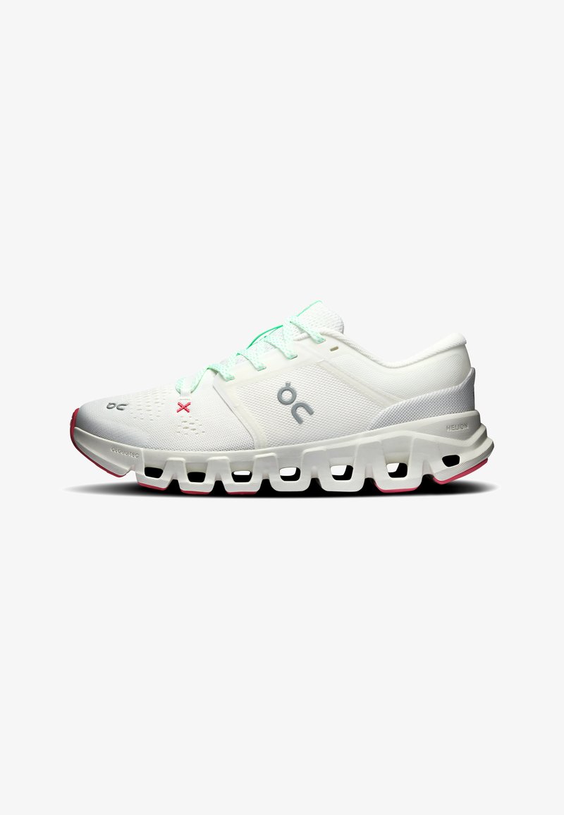 Chaussure de sport blanche avec une semelle segmentée unique, des lacets vert menthe et un logo sur le côté, présentée de profil droit sur fond blanc.