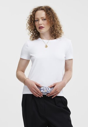 White short-sleeve t-shirt with a round neckline, paired with black trousers. A patterned belt bag is positioned at the waist.
