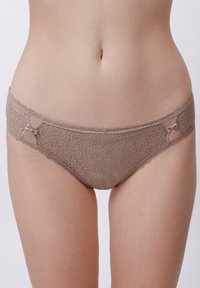Biancheria intima in pizzo di colore marrone chiaro con dettagli floreali, caratterizzata da una vita morbida e due fiocchi decorativi ai lati.