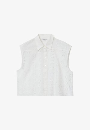 Blouse sans manches blanche avec un devant à boutons, présentant un motif floral en relief et un col classique. Fabriquée en tissu léger.