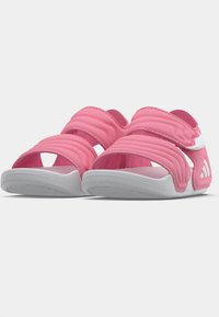 Roze sandalen met meerdere dikke bandjes, een wit accent en een lichtgrijze zool. Gestructureerd bovenwerk met open teen- en hielontwerp.