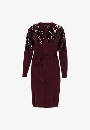 Vínová pletená šaty s dlouhými rukávy, se zdobením z flitrů na horní části hrudníku a rukávech a opaskem zavázaným v pase.