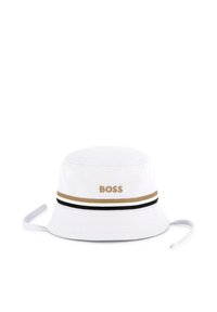 Bijela pamučna kape s oblikom kante s "BOSS" logom u zlatnoj vezilji, koja ima zlatno-crnu prugastu traku oko oboda i podesive vezice.