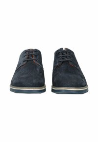 Scarpe in suede blu scuro con una superficie liscia, dotate di cinque fori per i lacci, dettagli arancioni e una striscia bianca a contrasto sulla linguetta.