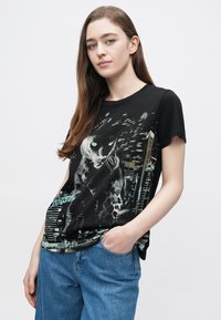 Čierne bavlnené tričko s grafickým motívom pantera so zelenými očami a akcentami mesta na pozadí, krátkymi rukávmi a voľným strihom.