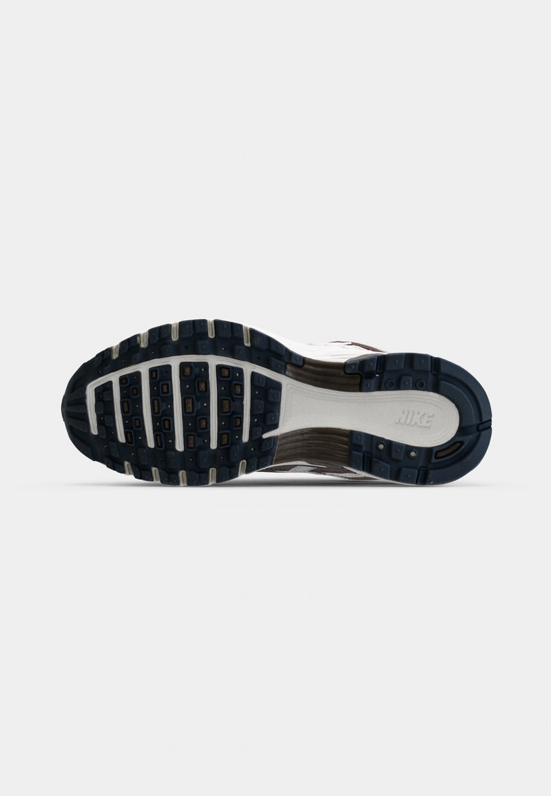 Nike hardloopschoen zool met een gestructureerde zwarte rubberen buitenzool, voorzien van een witte middenzool en grijze accenten, met zichtbare loopprofielen en branding.
