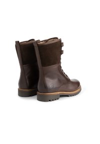 Bruine leren en suède enkellaarzen met vetersluiting aan de voorkant, twee verstelbare banden en een gestructureerde rubberen zool. Heeft een logo aan de zijkant.