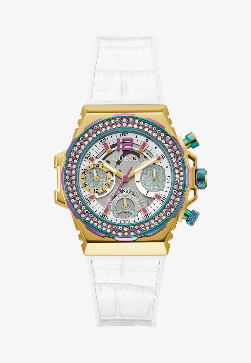 Montre dorée avec un bracelet en silicone blanc, cadran multicolore orné de strass, et trois sous-cadrans sur un fond argenté.