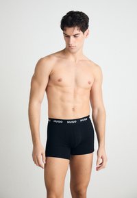 Schwarze Boxer-Briefs aus weichem Material mit enger Passform. Mit einem einfarbigen schwarzen Design und einem weißen "HUGO"-Logo am Bund.