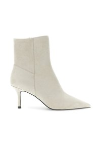 Bottines en suédine beige à bout pointu et talon slim de hauteur intermédiaire, fermeture à glissière latérale, texture lisse.