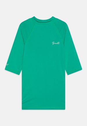 Τιρκουάζ ραγκόσχολος με μακριά ρανγκλάν μανίκια, κατασκευασμένος από ελαστικό ύφασμα. Διαθέτει καμπυλωτό λαιμό και εκτυπωμένο λογότυπο στο στήθος και στο μανίκι.