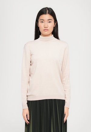 Light pink, long-sleeve turtleneck sweater made of a soft, smooth fabric with a fitted silhouette, paired with a dark pleated skirt.