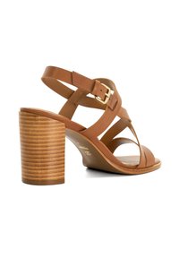 Brown leather high-heeled sandals with crisscross straps, a side buckle, and a striped wooden block heel. Flat sole and open toe design.