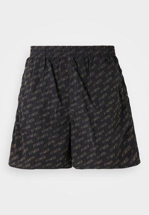 Fekete rövidnadrág, amelyet a "DIESEL" szó fényes aranyszínű mintázatba szőttek. Rugalmas derék, laza és kényelmes szabás.