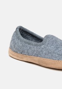 Grå slip-on sko i følt med blød ruskindsål, rund tå og syede detaljer langs kanten. To-tonet tekstur med glat finish.