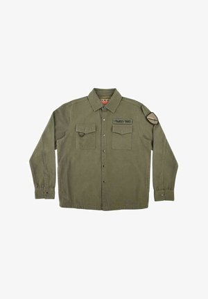 Camisa de color verde oliva con botones, dos bolsillos delanteros, parche de "Stranger Things" en el pecho y parche circular en la parte superior izquierda de la manga.