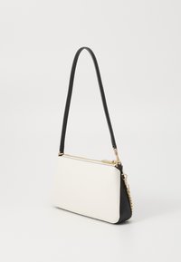 Compact handbag featuring a textured white leather body, black accents, a slim strap, and gold zipper detailing.